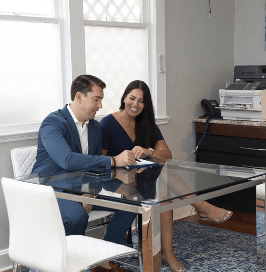 An attorney reviewing paperwork with a smiling client at the Sunshine State Law Firm office