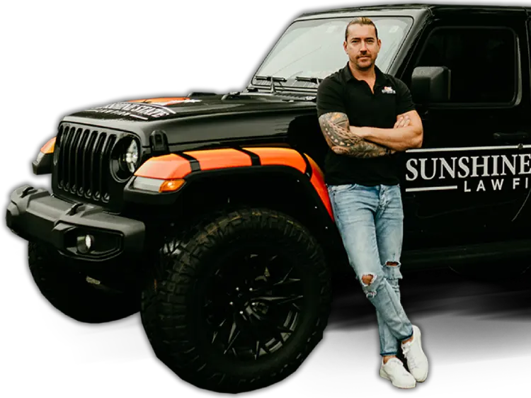 A Sunshine State Law Firm team member leaning on the black Sunshine State Law Firm Jeep