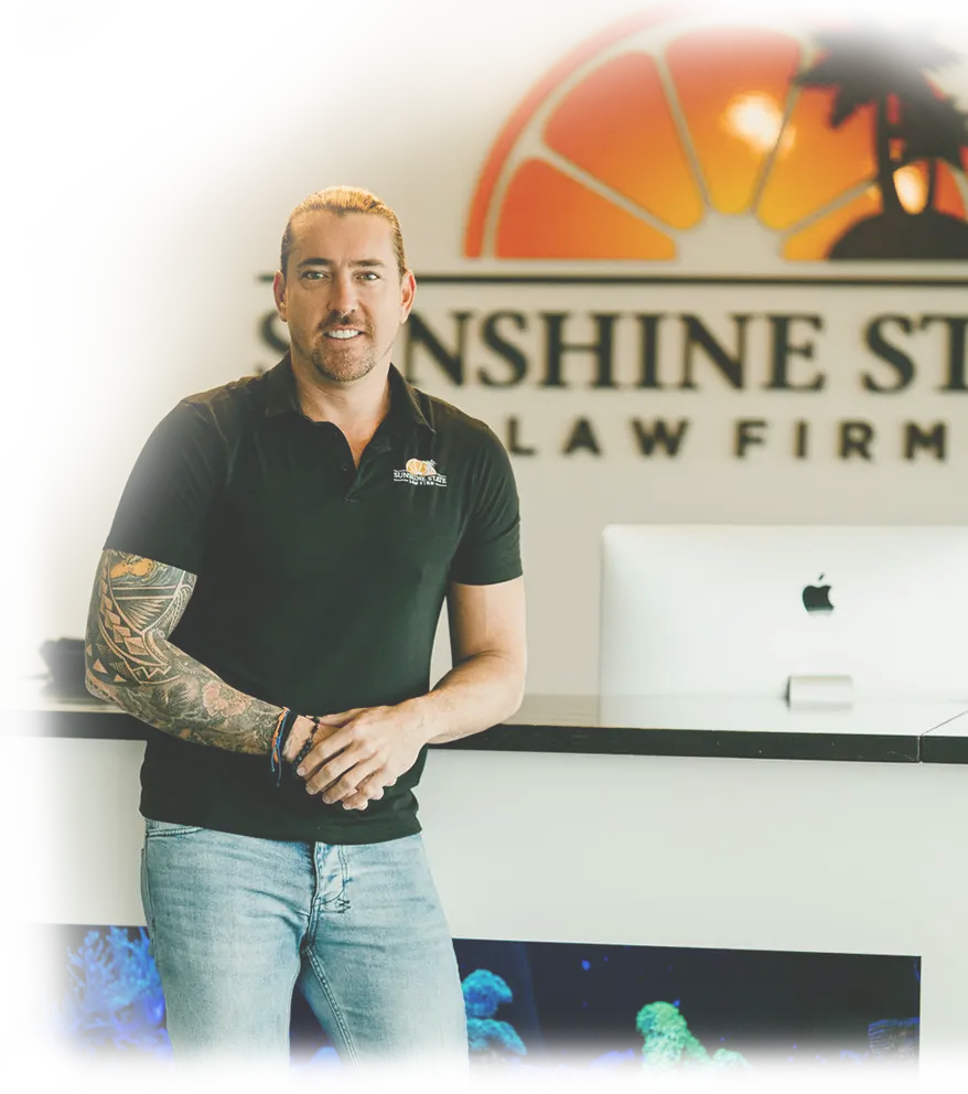 A Sunshine State Law Firm team member in front of the firm’s logo wall